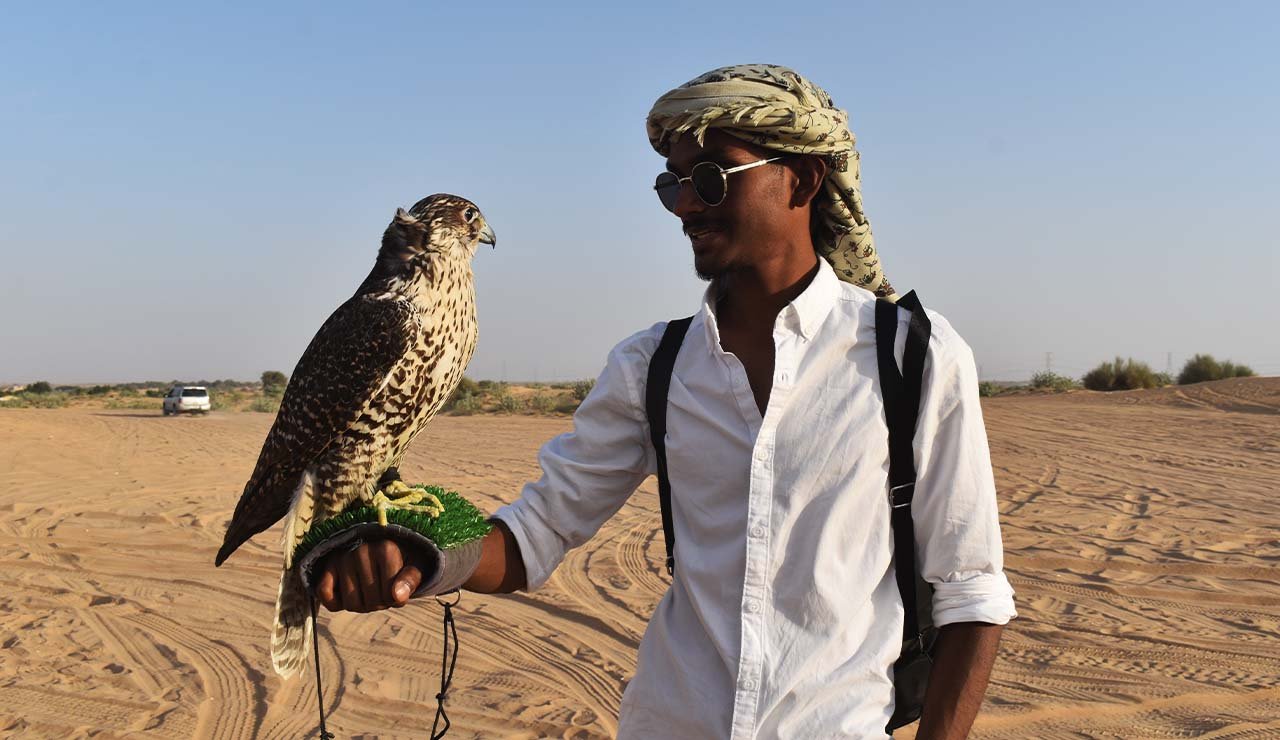 boy with falcon in desert